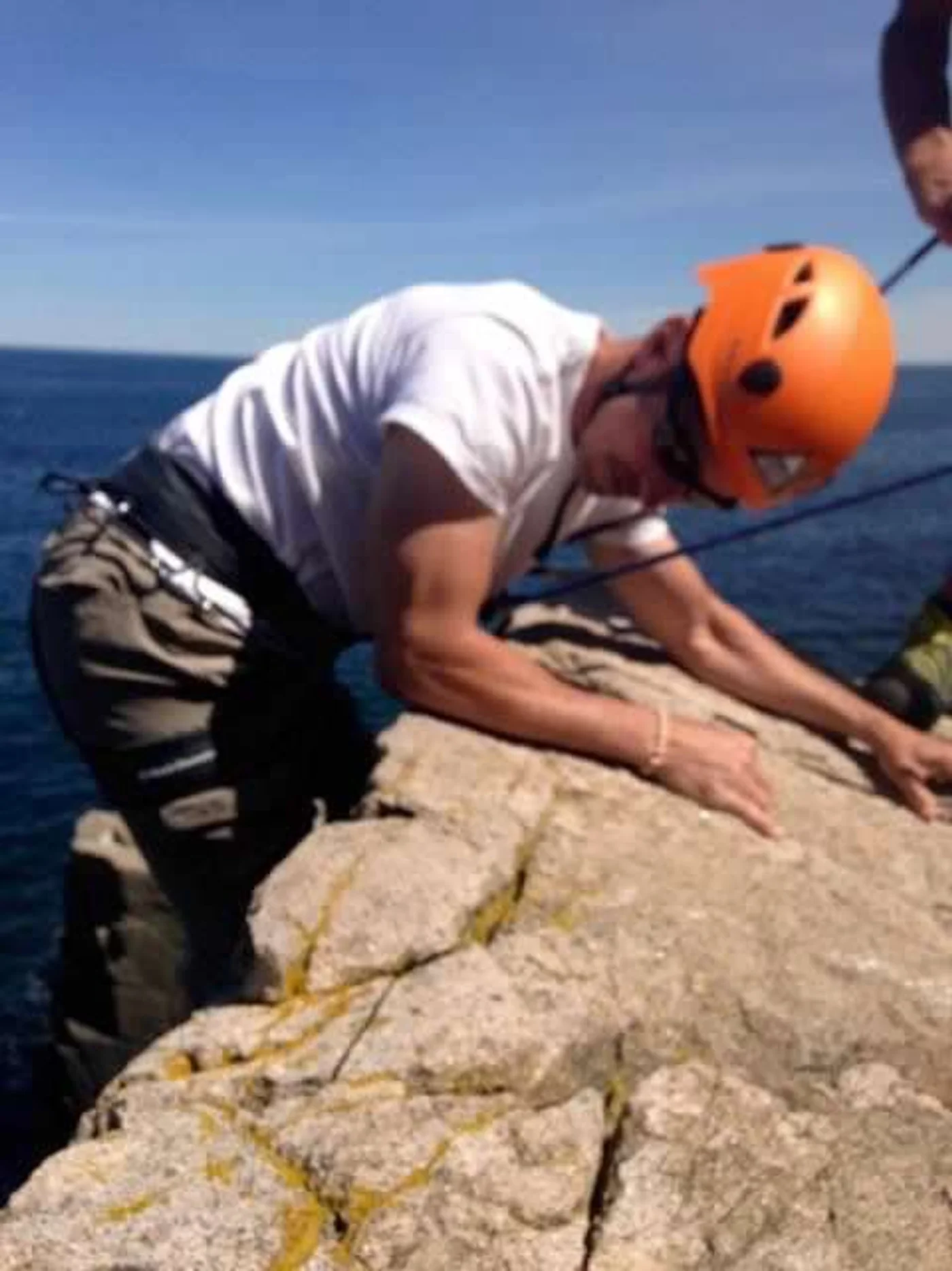Setting up the rappel at Acadia — ocean below, granite above, the whole Atlantic as a backdrop